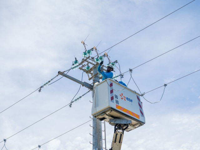 Le technicien réalise son intervention sur la ligne électrique aérienne haute tension